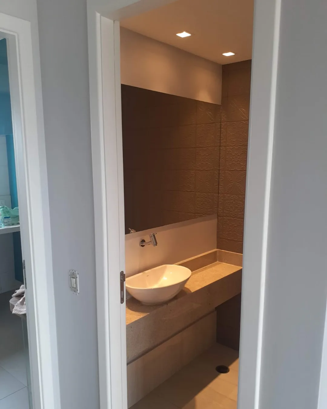 Lavabo reformado com bancada, espelho e acabamento contemporâneo